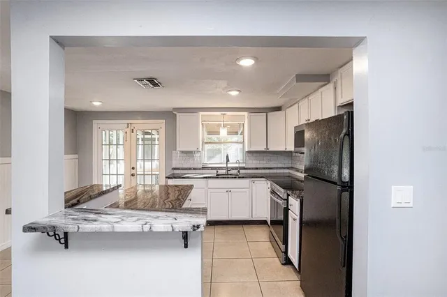 a kitchen with kitchen island granite countertop cabinets and refrigerator