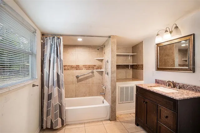 a bathroom with a tub sink double vanity and mirror