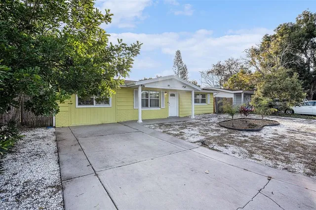 a view of a house with a yard and large tree
