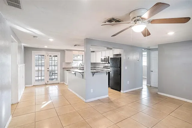a large kitchen with stainless steel appliances granite countertop a refrigerator and a sink