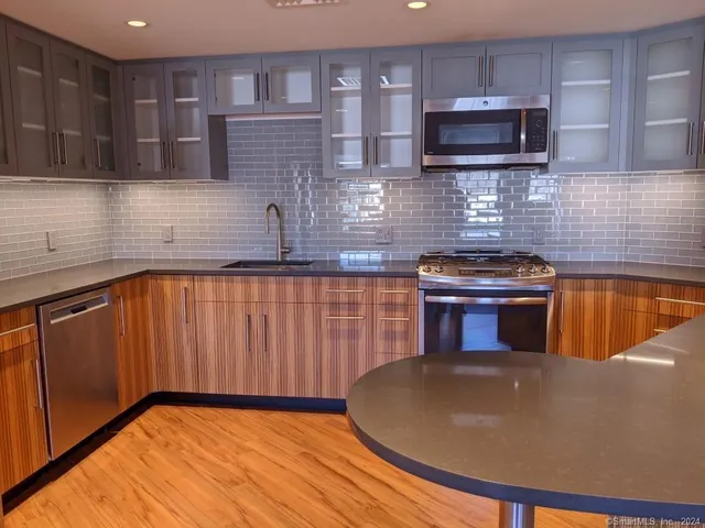 a kitchen with a sink a microwave and cabinets