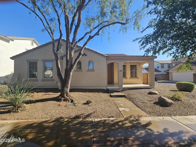 a tree in front of a white house