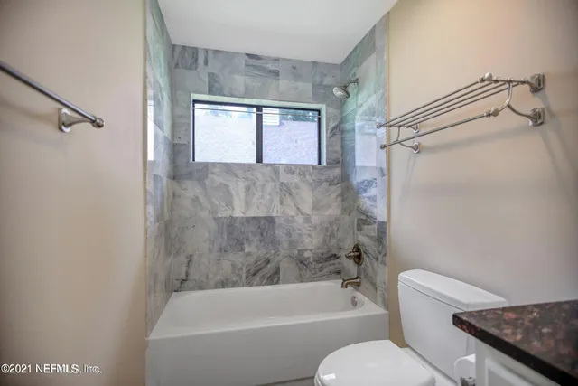 a bathroom with a toilet and a bathtub