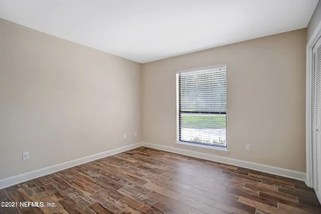 wooden floor in an empty room with a window