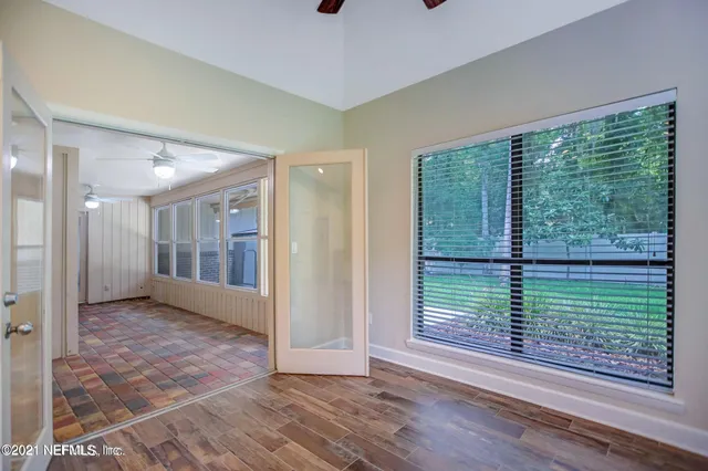 a view of empty room with wooden floor and fan