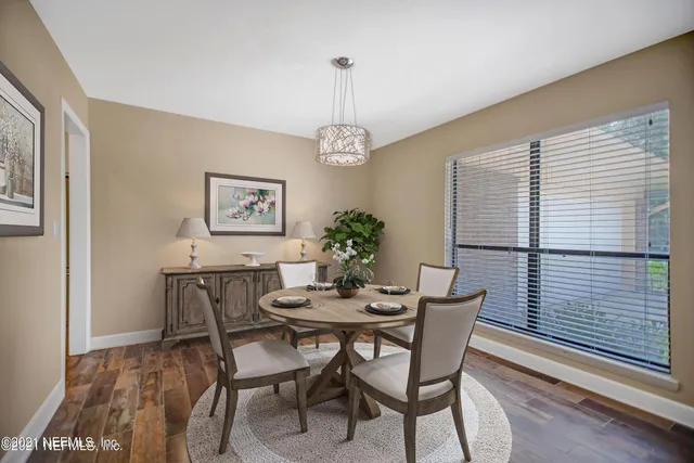 a dining room with furniture a chandelier and wooden floor