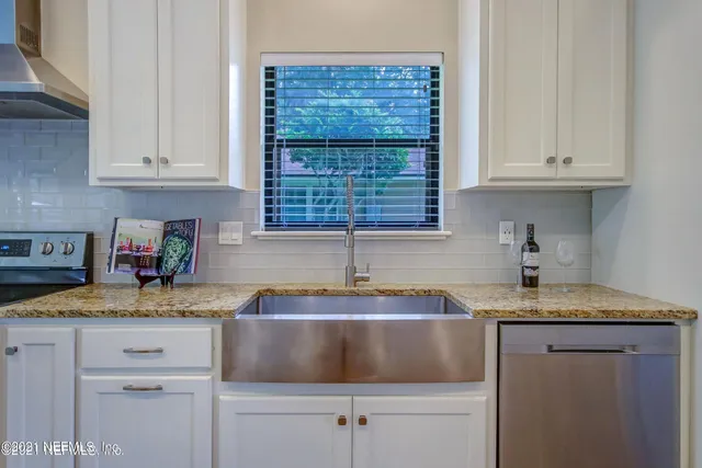 a kitchen with granite countertop white cabinets and a sink