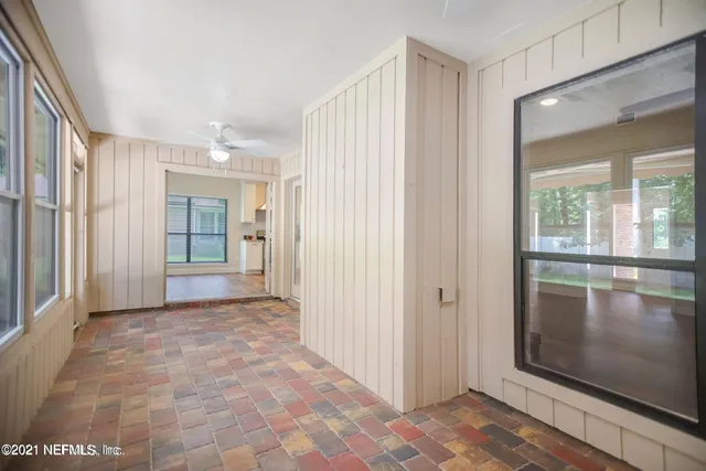a view of a hallway with wooden floor and a living room