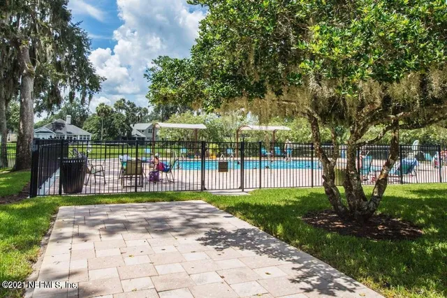 a view of a park with large trees and a small yard