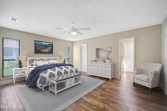 a spacious bedroom with a bed a couch and dresser