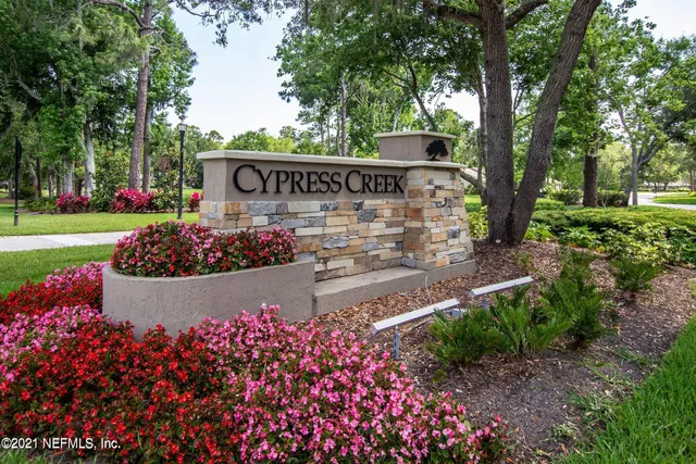 a view of a sign board with flower garden