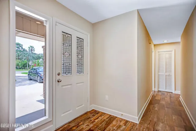 a view of a hallway with wooden floor and a livingroom