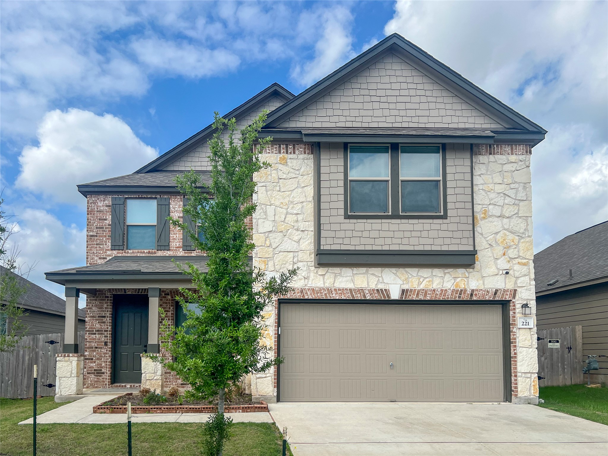 221 Summit Drive Lockhart, TX 78644 - Photo 1 of 16 a front view of a house with a garden