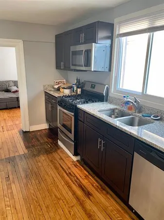 a kitchen with stainless steel appliances granite countertop a sink stove and cabinets