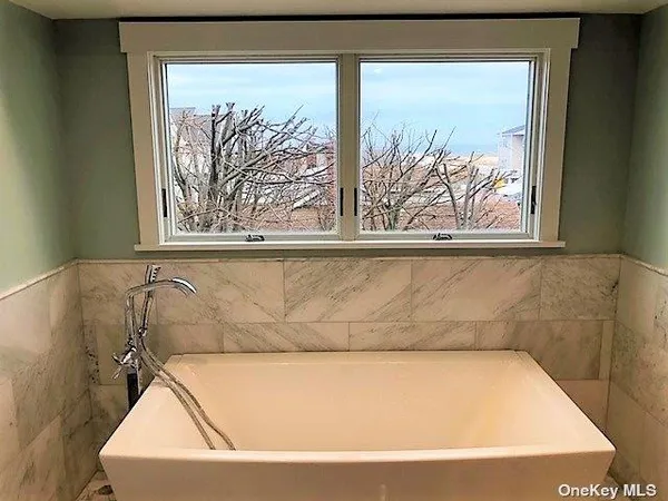 a bathroom with a bathtub and window