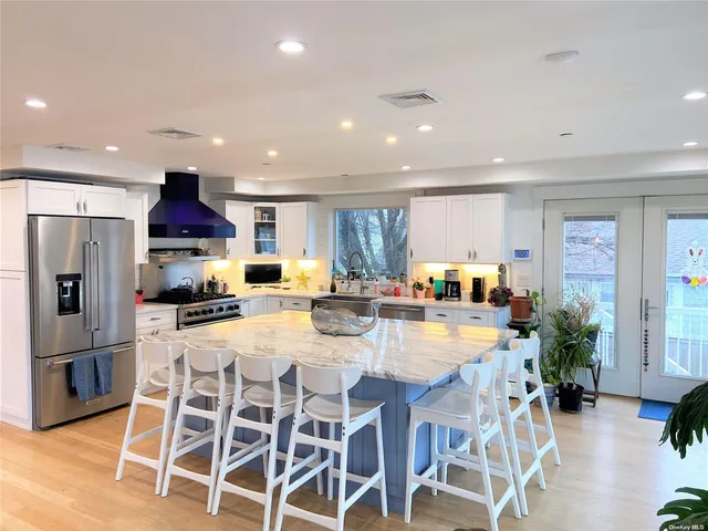a view of a dining room with furniture a kitchen and chandelier
