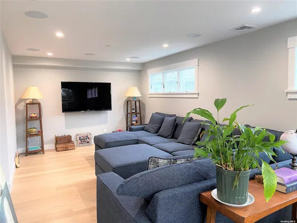 a living room with furniture potted plant and a flat screen tv