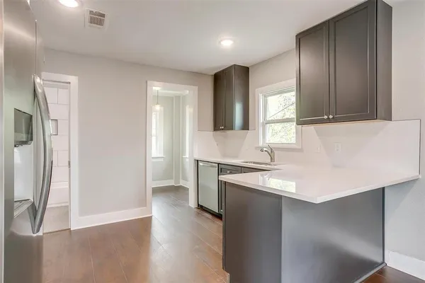 a kitchen with granite countertop a sink and a stove top oven