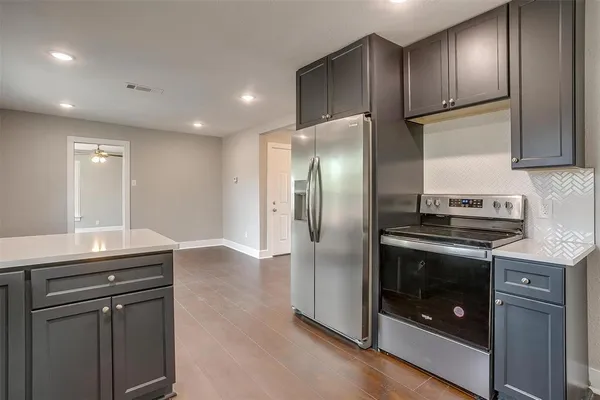 a kitchen with granite countertop stainless steel appliances and wooden cabinets