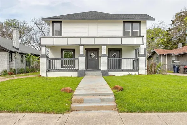 a front view of a house with a garden and yard