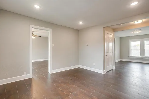a view of empty room with wooden floor and window