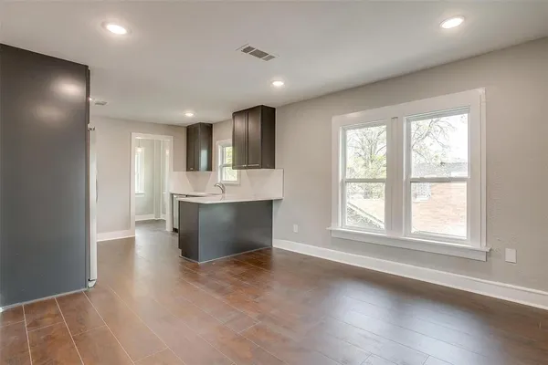 a view of kitchen with kitchen island wooden floor center island and windows