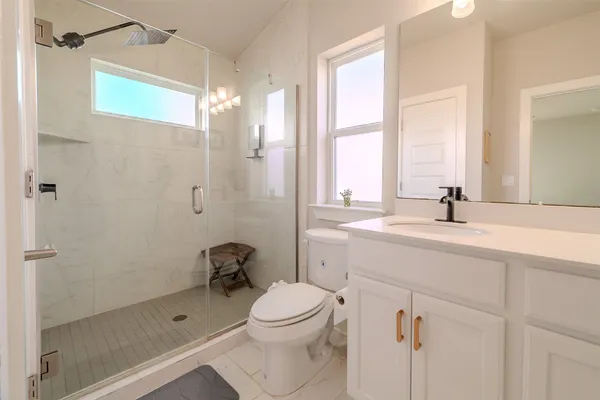 a bathroom with a sink a toilet and shower