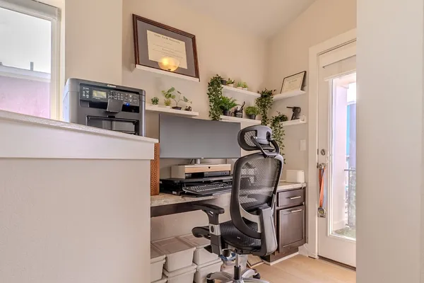 a view of a workspace with furniture and gym cycle