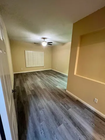 a view of an empty room with wooden floor