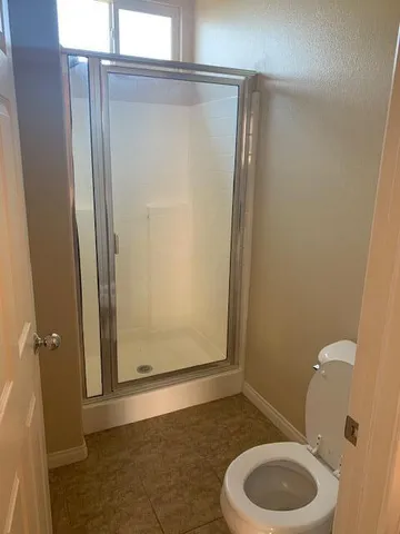 a bathroom with a toilet and a shower