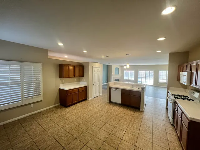 a large kitchen with stainless steel appliances a large counter top a stove a chimney a sink and cabinets