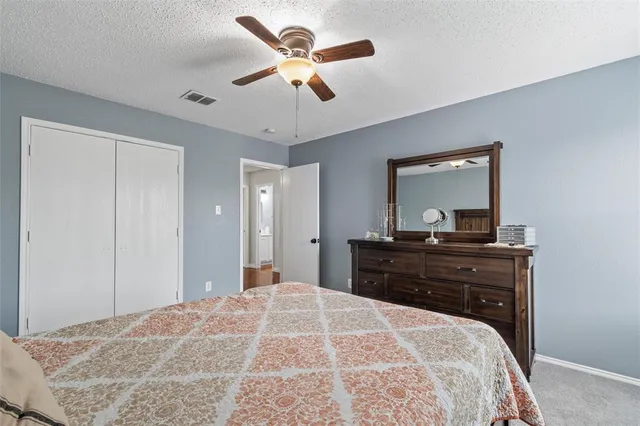 a bedroom with a bed a chandelier and a desk