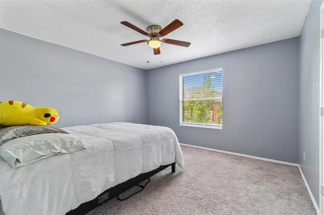 a bedroom with a bed and a ceiling fan