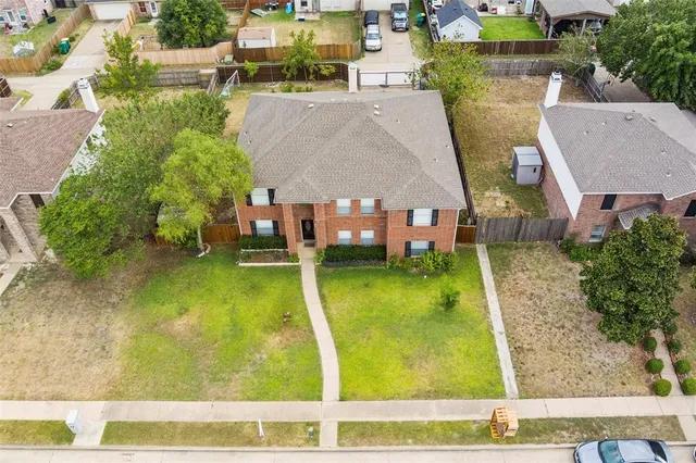 an aerial view of a residential houses with yard