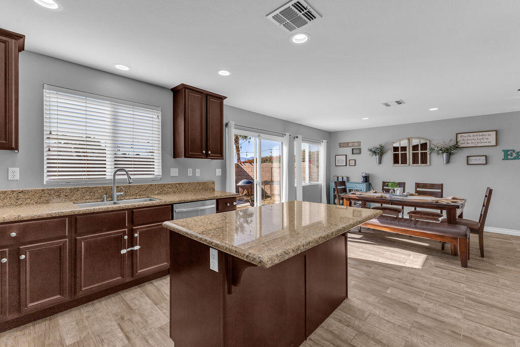 84285 Tramonto Way Indio, CA 92203 - Photo 12 of 63 a dining hall with stainless steel appliances granite countertop a sink and dishwasher a stove with wooden floor