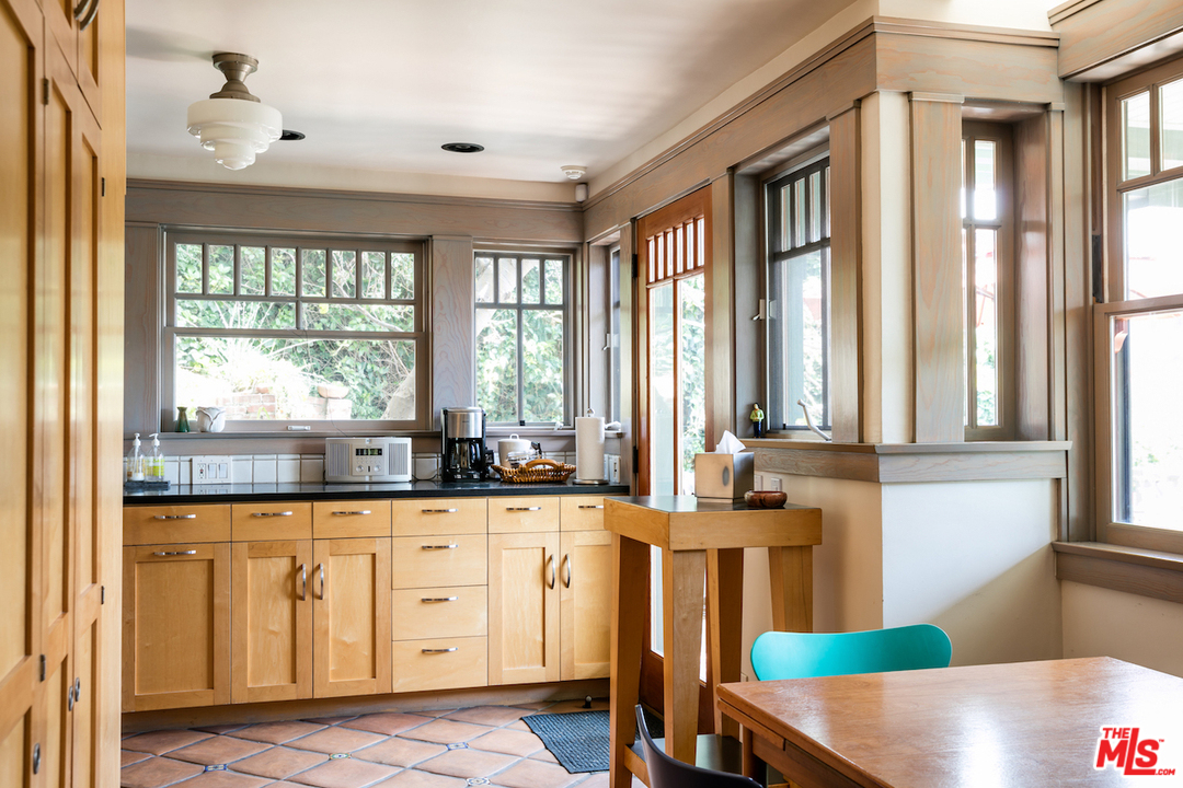 239 West Channel Road Santa Monica, CA 90402 - Photo 11 of 30 a large kitchen with white cabinets and wooden floors