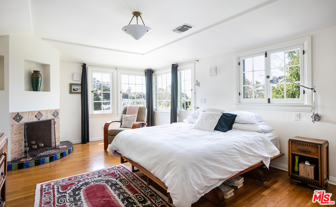 239 West Channel Road Santa Monica, CA 90402 - Photo 18 of 30 a bedroom with a bed a fireplace and a flat tv screen