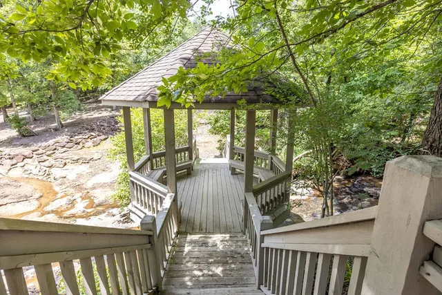 a backyard of a house with trees and outdoor seating