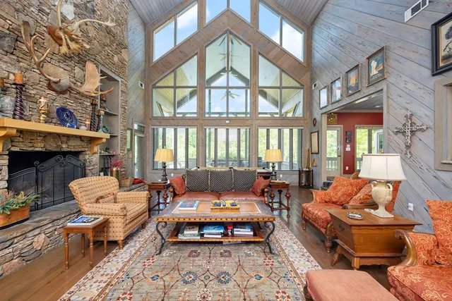 a living room with furniture a fireplace and a floor to ceiling window