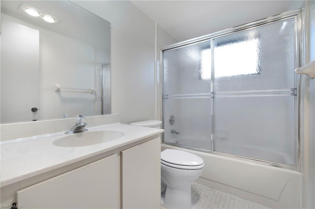 1814 Kings Lake Boulevard, Unit 201 Naples, FL 34112 - Photo 13 of 18 a bathroom with a sink toilet and shower