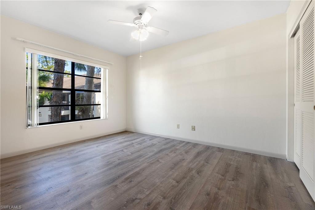1814 Kings Lake Boulevard, Unit 201 Naples, FL 34112 - Photo 14 of 18 wooden floor in an empty room with a window