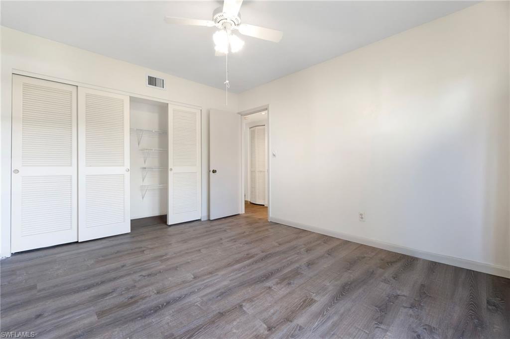 1814 Kings Lake Boulevard, Unit 201 Naples, FL 34112 - Photo 15 of 18 a view of an empty room with wooden floor