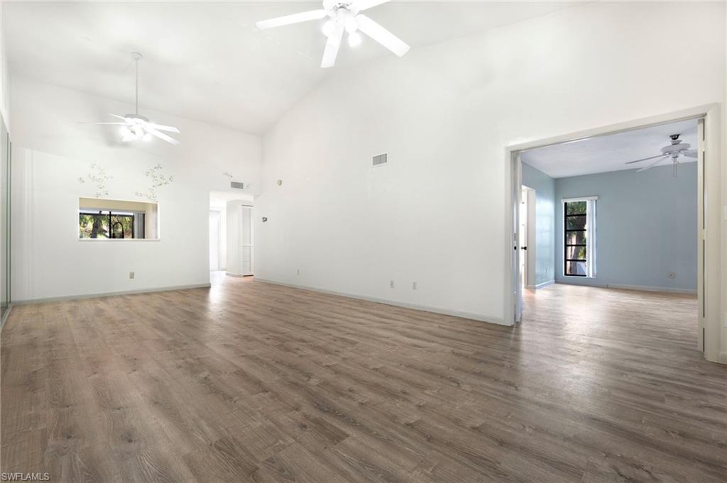 1814 Kings Lake Boulevard, Unit 201 Naples, FL 34112 - Photo 8 of 18 an empty room with wooden floor and windows