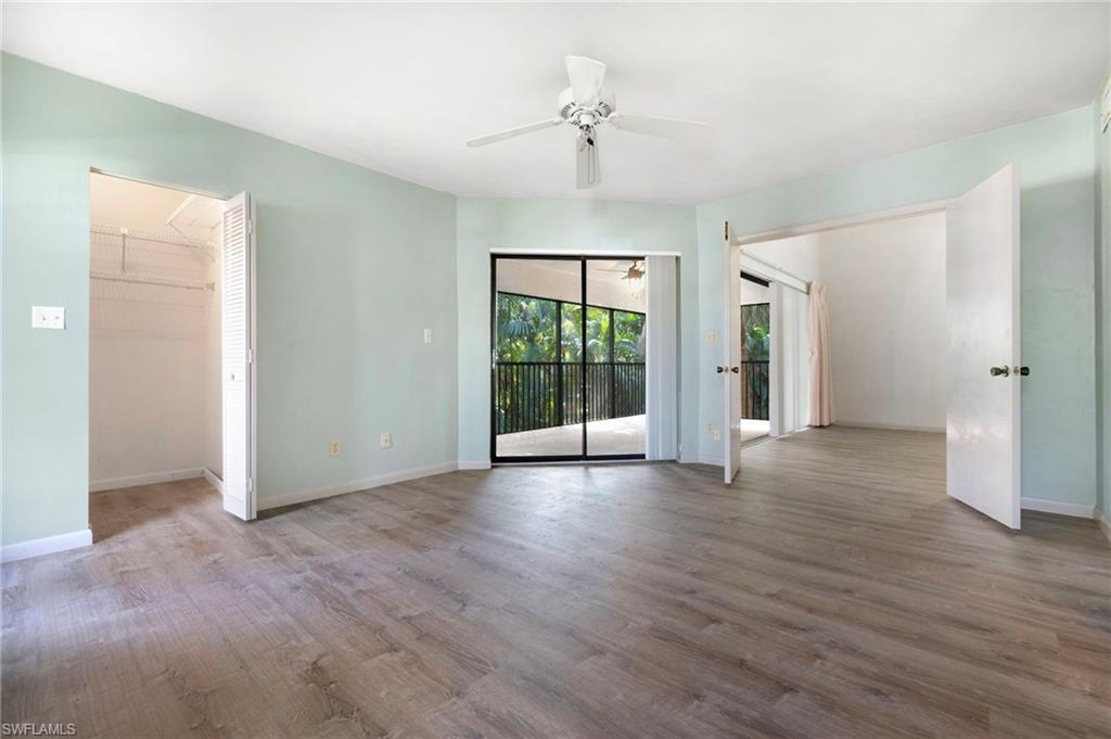 1814 Kings Lake Boulevard, Unit 201 Naples, FL 34112 - Photo 10 of 18 a view of an empty room with wooden floor and a window