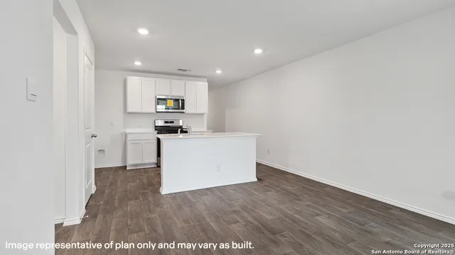 a view of a kitchen with refrigerator and wooden floor