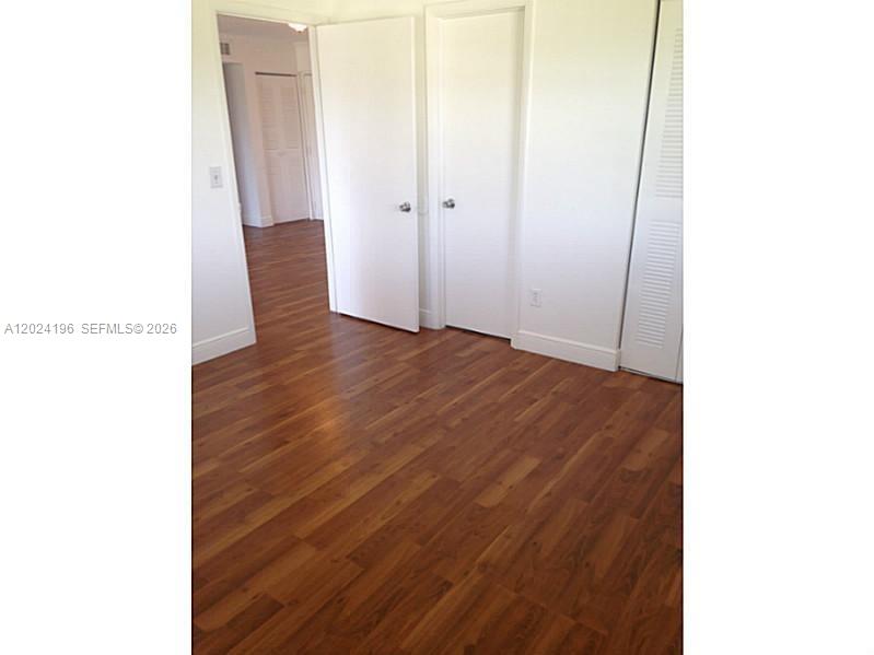 8260 Southwest 210th Street, Unit 319 Cutler Bay, FL 33189 - Photo 3 of 20 a view of an empty room with wooden floor