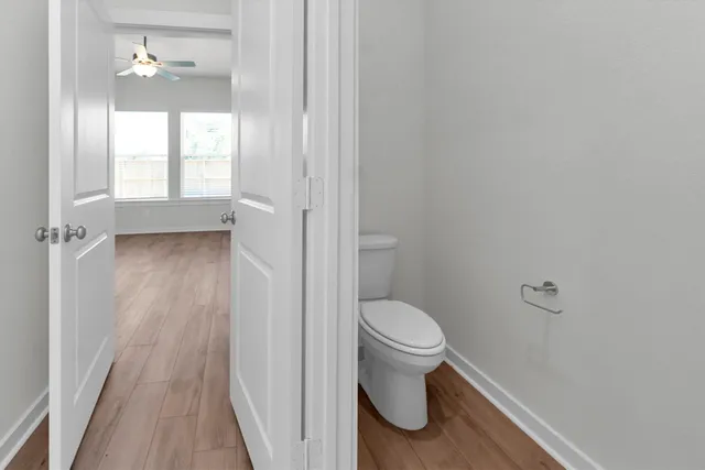 a white toilet sitting next to a white wall