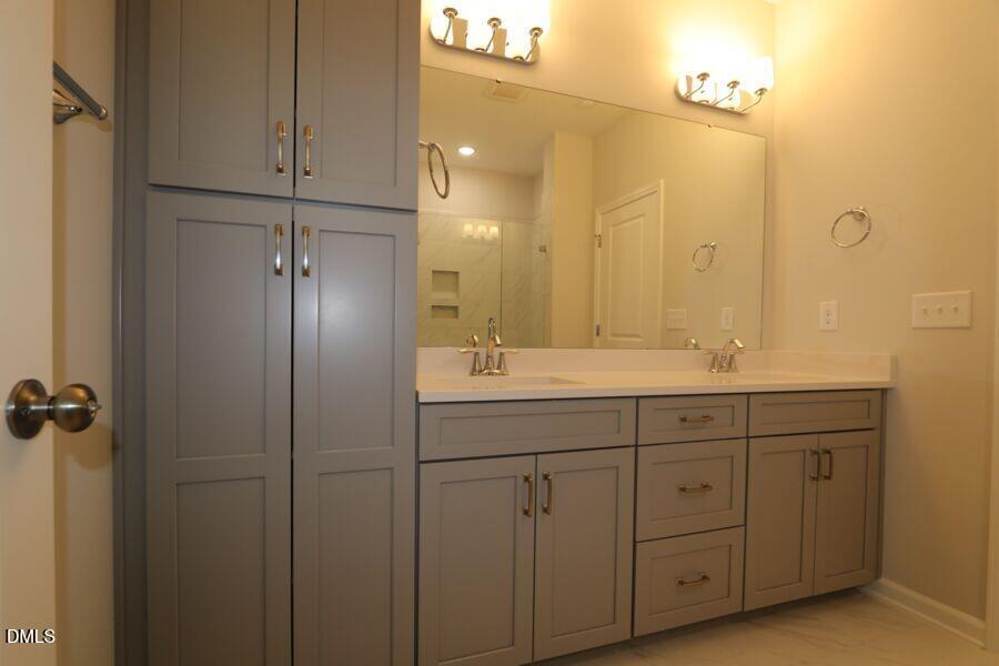 2913 Richardson Road, Unit 475 Apex, NC 27502 - Photo 13 of 24 a bathroom with a double vanity sink a mirror and shower
