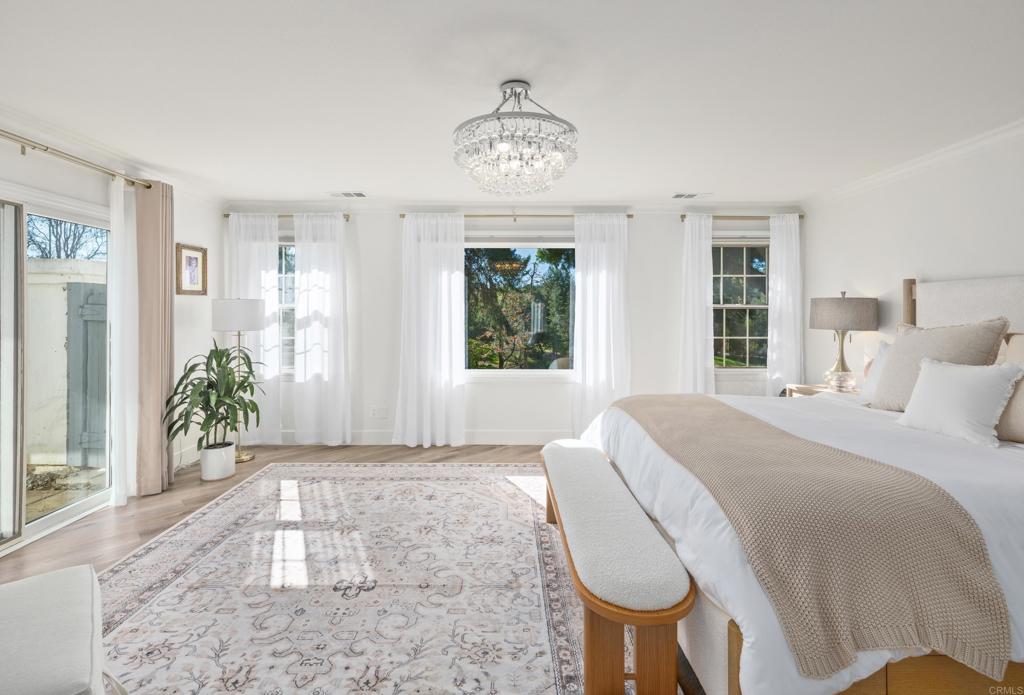 9 Country Glen Road Fallbrook, CA 92028 - Photo 23 of 74 a spacious bedroom with a bed and a chandelier