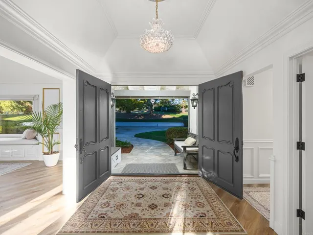 a view of a patio with table and chairs potted plants and large tree
